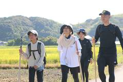 2026年の武者修行：田畑と山を背景に道を歩く参加者たち