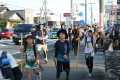 2026年の武者修行：杖を手に、街なかを歩く参加者たち